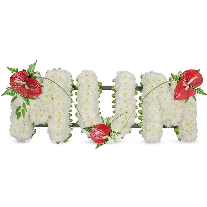 A poignant, expertly made memorial piece spells the single word MUM in elegant block letters, each letter formed from a dense, immaculate carpet of white spray chrysanthemums set against a plain white background. The chrysanthemums are chosen for fullness and purity and are placed so close together that the letters read as soft, voluminous panels - comforting to the eye and imbued with quiet grace. A low-profile dark green framework supports the shape, visible only as a slim, reassuring outline where the blooms are trimmed, lending a subtle contrast that keeps the composition grounded. Bright, glossy red anthuriums - with their distinctive heart-like spathes and pale central spadices - are used as poignant focal points: one sits on the upper left curve of the first M, another nestles into the lower curve of the U, and the last crowns the upper right of the final M. Each anthurium is cradled by sprigs of dark green foliage, including feathered fern fronds and broader leaves, which bring depth and a woodland freshness to the arrangement. Thin, arching green stems or blades of grass flow between the red accents, creating a soft, sweeping line across the white letters that unites the composition and draws the eye gently from left to right. In the soft, even daylight of a chapel or funeral parlour - familiar settings for many families around Stanmore and the nearby Bentley Priory - this tribute reads as an intimate, respectful expression of enduring love and remembrance for a mother, offering both beauty and solace in a time of loss.