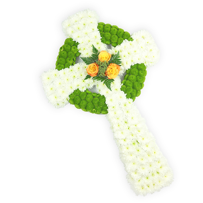 Presented on a stark white surface and viewed from just above, this Celtic cross arrangement reads as a sculpted, three-dimensional homage: the primary mass is formed from plentiful white spray chrysanthemums whose small, textured heads create a soft, continuous plane across the arms and lower shaft. Bright, almost lime apple-green button chrysanthemums are woven into the composition in deliberate bands, defining the cross's circular centre and appearing in alternating patches along the horizontal arms to suggest the interlaced geometry of Celtic ornament. centered in that ring is an intimate cluster of three vivid orange-yellow roses, their petals warm and luminous against the cooler tones; they are edged by a few sprigs of dark green fern, offering both visual framing and a leafy counterpoint. The lighting is crisp but gentle, throwing subtle shadows that accentuate the depth and rounding of each bloom, while the petals' textures-from the velvety rose to the papery chrysanthemum-invite a tactile imagination. The colour story-white, green, and orange-yellow-can evoke the Irish tricolour and is particularly appropriate for memorials honoring Irish identity or spiritual faith. As a seasoned Stanmore florist I see this piece fitting in quiet services near Stanmore tube or laid at community remembrances by local churches; its measured composition conveys respect, consolation, and the attentive hand of a florist who understands ceremonial floristry and local sensibilities.