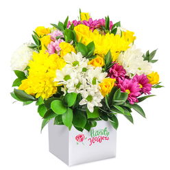 A vibrant, dome-shaped floral arrangement rises from a sleek white cube box, set against a pure white background that allows every detail to stand out clearly. This bouquet is a lively blend of yellow, white and deep pink blooms, reminiscent of the colourful displays seen in well-kept front gardens along Stanmore Hill. At its heart, volume-rich yellow chrysanthemums dominate, their many layered petals forming plush, rounded heads that convey warmth and cheer. Nestled among them are clusters of yellow spray roses, ranging from tight buds to partially open flowers, their petals soft and slightly waxy in appearance, lending romance and intricate texture. Punctuating the arrangement are crisp white daisylike chrysanthemums with bright green centres, which add a fresh, informal touch, alongside larger white chrysanthemums that bring extra fullness and visual softness. Running through this tapestry are fuchsia and magenta chrysanthemums, some subtly tinged with lighter pink, creating bold streaks of colour that draw the eye. Occasional pink and yellow rosebuds are scattered among the larger flowers, hinting at new blooms still to come. The rich, deep green foliage, glossy and robust, tucks around the base and threads between the petals, framing the bouquet and giving it a structured, finished look. The minimalist white box works as a contemporary container, versatile enough to sit comfortably in a modern Stanmore apartment or a traditional home near Bentley Priory. This arrangement appears ready for local flower delivery, perfect for brightening a living room, sending a get-well message, or acting as a joyful centrepiece for Shabbat dinners and family gatherings across Stanmore.