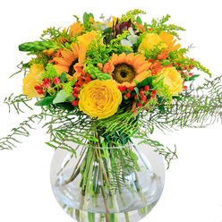 This lush Stanmore bouquet radiates pure summer vitality, gathered with care and arranged to evoke the serene beauty found near Bentley Priory Nature Reserve. At its core, majestic sunflowers capture the sunlight, their golden petals fanning outward in bold, cheerful layers around deep brown centers. Interwoven throughout are sumptuous yellow garden roses, each a masterpiece of delicate spirals that gently open to invite the eye and the senses. The bright reds of Hypericum berries add a charming, whimsical counterpoint, like laughter scattered across lush green meadows. Fern fronds droop gracefully from the cluster, softening the composition's edges with their feathery texture, much like the gentle movement of tall grasses that line Stanmore's walking trails. Pale sprigs, likely goldenrod or solidago, introduce slender bursts of light green and sunshine-yellow, further enhancing the arrangement's sense of depth and airiness. Wisps of eucalyptus, with their muted blue-green tones, peek discreetly among the bolder hues, grounding the bouquet in a natural, slightly rustic touch. All are gathered in a pristine, round glass vase, where the stems crisscross in clear, sparkling water, highlighting the freshness and vitality of every bloom. The bouquet's subtle fragrance-soft rose, sun-warmed greenery, a tinge of wild earth-suggests afternoons spent wandering local fields. Suitable for a joyful birthday, a heartfelt thank you, or simply to brighten a Stanmore home, this arrangement is a tribute to floristry rooted in local tradition and delivered with warmth.