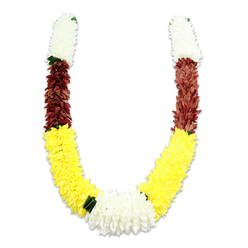 There is a calm dignity in this U-shaped floral mala, placed against a stark white backdrop so every hue and texture is plainly visible. From each top end a compact cylinder of snow-white, chrysanthemum-like blooms forms a soft, inviting start; each petal is a tiny, fabric curl packed together to give an almost cloud-like volume. These white segments transition into a deep, rust-maroon band, a warm, grounding counterpoint whose tightly arranged petals create a velvet ribbon around the curve. The garland then eases into a long, generous run of bright yellow blossoms that form the dominant visual arc-these petals are plush and dense, conjuring the sunny cheer of marigolds laid out for celebration. Where the yellow arcs meet in the centre, a broad cluster of pure white flowers creates a serene focal knot, subtly punctuated by small dark-green leaf accents that suggest natural separation between the colour zones. Studio lighting produces a soft shadow along the inner curve, lending depth and the impression of weight though the piece is crafted from lightweight synthetic fabrics. The piece reads as ceremonial and lovingly made: suitable for Hindu puja, temple offerings, Diwali or wedding rituals, and as an emblem of welcome or respect. As a Stanmore florist might arrange for delivery to homes near Stanmore station or to community events around Stanmore Hill, the garland's colours-white for purity, yellow for prosperity, maroon for devotion-speak quietly to tradition while the durable fabric construction ensures it will remain serviceable and visually striking through many seasons of use.