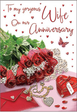 This composition reads like a private love letter made visible: a snug posy of crimson roses, their swirling petals rich and tactile, seem almost to spill from the card at the centre. Plush fronds of fern and glossy greenery weave between the blooms, adding contrast and life while catching the soft daylight that frames the scene. Scattered over the romantic tableau are tiny tokens that nudge at memory - a scarlet jewellery box bound in ribbon, a golden necklace shaped into intertwined hearts, and a handful of sparkling confetti hearts that tumble gently across lace and satin. Laid just below, a folded envelope and a handwritten message float amid the arrangement, the script like a whispered vow. The textures are pronounced: the cool metal of the necklace against the velvet box, the dewy collar of each rose, and the whisper-thin lace that softens the edges. A lone butterfly rests among the blooms, suggesting tender motion, while pearls and a heart-shaped locket glimmer in the softened light. There is a faint scent in the imagining - heady rose, warm ribbon, and a hint of citrus leaf - that makes the scene immediate. As an experienced florist who often assembles keepsake pieces for anniversaries in Stanmore, I picture this laid out on a side table after tea on Stanmore High Street, each element chosen to evoke lasting devotion and to invite a quiet, shared celebration of years together.