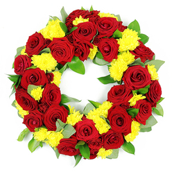 This image shows an elegant memorial wreath set against a spotless white backdrop, its circular shape densely packed with deep red roses and cheerful yellow chrysanthemums. The wreath's open centre and continuous ring convey a feeling of eternity, while the lavish abundance of flowers speaks of care and reverence. The red roses, fully open and velvety, display intricate spirals of petals that range in tone from bright crimson to darker, wine-red shades, giving the piece a rich, layered depth. Between them, clusters of yellow chrysanthemums, most likely button or spray varieties, glow like small suns, their countless slender petals creating a gentle, almost cloud-like texture. Supporting this interplay of colour, the foliage is varied and thoughtfully placed: some leaves are broad and shining, a deep, healthy green that anchors the design; others are softer with a muted, grey-green cast that calls to mind eucalyptus, adding visual softness around the edges. The flowers appear freshly cut, with crisp petals and vibrant colour suggesting they have been arranged that day by a local Stanmore florist, perhaps in a workshop near Canons Park or close to Stanmore Tube station. The white background and balanced lighting strip away any distraction, allowing full focus on the wreath's form and symbolism. It feels ideal for a funeral or commemoration service, whether resting beside a coffin in a chapel or laid gently at a graveside in one of Stanmore's peaceful burial grounds, offering an expression of sympathy that blends dignity, warmth, and heartfelt remembrance.