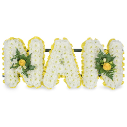 Gracefully formed and quietly dignified, this MAM tribute has been composed to honour a much-loved mother or maternal figure, with attention to both sentiment and structure that comes from years of local floral work around Stanmore Broadway and the High Street. Each of the three capital letters is densely made from tiny white chrysanthemum spray flowers, their clustered petals creating a soft, textured field that reads as calm and pure. A bright yellow pleated ribbon neatly borders each letter, its sunny tone framing the white blooms and lending a subtle uplift to the design. The outer Ms are finished with small accent clusters centred on a softly furled yellow rose bud; surrounding the roses are slender white freesia blooms - their light, citrus-like fragrance almost perceptible - and an assortment of deep green foliage including feathery fern fronds and smooth glossy leaves that give contrast and shape. Behind the upper sections a slim dark green or black support bar ties the letters together invisibly, ensuring the arrangement sits securely on an easel or ledge at a funeral or memorial. The image is set against a crisp white background so colour and texture remain the focus. At Flower Delivery Stanmore we often prepare similar personalised tributes for services near Stanmore tube and Canons Drive, mindful of the need for both careful craftsmanship and a gentle, respectful presence at a time of farewell.