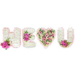 This refined sympathy and celebration piece spells H E (heart) U in classic, restrained tones, a bespoke tribute that reads as clearly from across a chapel or family room. The letters H, E and U are formed from tightly packed white chrysanthemums, their tiny blooms creating a smooth, cloud-like texture finished with a pale blush satin ribbon that softens each edge and lends a handcrafted, ribboned silhouette. Fuchsia pink roses are positioned as bright punctuation marks at the edges and curves - two by the H, a central trio across the E's middle bar, and a small spray tucked into the inner curve of the U - each paired with deep green ferny foliage and small reddish-pink berries for depth and seasonal contrast. The heart at centre differs in palette and mood: an intimate bouquet of soft pink carnations, delicate blush lisianthus or spray roses and generous pale-green eucalyptus leaves arranged to create a gentle, aromatic heart that draws the eye and the breath. Lighting is even and clear, the white background amplifying the pinks and greens so the composition reads with dignity and tenderness. As a Stanmore florist familiar with local services close to Canons Park and the tranquil lanes around Bentley Priory, I design pieces like this for families seeking a message of love and remembrance; Flower Delivery Stanmore can create and deliver this tribute across Stanmore and nearby Harrow with sensitivity and freshness.