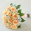 Hand-tied in Stanmore with artistry and care, this mesmerizing bouquet blends classic beauty with a touch of romantic charm-created for meaningful moments celebrated from Marsh Lane to Old Church Lane. A gentle gathering of peach and golden apricot roses unfolds in lush, velvety spirals, their soft gradients glowing with quiet warmth beneath the gentle daylight. Wisps of white baby's breath form a halo around the blooms, casting a lace-like effect that suggests hope and new beginnings. Fresh, glossy greenery, reminiscent of the grand trees around Canons Park, cupps the arrangement, providing a lively contrast and enhancing the harmony of the pastel tones. The stems are gathered and wrapped in a wide peach satin ribbon, delicately detailed with an array of small white pearls in orderly rows, offering a smooth, romantic texture to the hand. Set against a subtly textured, neutral fabric, every detail shines-from the dewy freshness of each petal to the tranquil balance of colour. Fragrant and uplifting, this bouquet is the ideal choice for weddings, anniversaries, or momentous celebrations within Stanmore, inviting a sense of joy, tenderness, and lasting love.