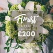 A stunning and lush bouquet dominated by crisp white and vibrant lime green flowers is presented as a premium Florist Choice arrangement. Large white lilies unfurl their smooth, ivory petals, radiating calm grandeur, while clusters of soft white ranunculus or spray roses add volume and a delicate, cloud-like texture around them. The lime accents arrive in bold, sculptural pockets-Green Trick dianthus or compact lime hydrangea-providing a vibrant, contemporary zing that keeps the design modern and uplifting. Rich, dark green foliage, including eucalyptus and ruscus, threads through the arrangement, lending structure, depth, and a natural garden feel. The bouquet appears to be held by a person, with light-coloured attire glimpsed in the softly blurred upper left background, suggesting a special occasion in Stanmore. At the center, a crisp white rectangular frame overlays the image, with Florist Choice read in elegant script above BOUQUET in uppercase, and a large 200 insert beneath as a premium cue. The composition exudes refined luxury, expert craftsmanship, and a sense of quiet celebration ideal for weddings, anniversaries, or grand gifts. This piece reflects Flower Delivery Stanmore's commitment to fresh, meticulously arranged florals delivered with care to Stanmore and surrounding neighborhoods, with same-day options available for memorable moments and thoughtful gifting.