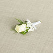 A timeless boutonnière designed for a wedding or formal celebration is captured here on a softly woven, light-coloured cloth, its subtle texture bringing quiet depth to the scene. The central focus is a single creamy ivory rose, its petals arranged in gentle, unfolding layers, giving the flower a serene, almost luminous quality. Surrounding the rose is a cluster of white baby's breath, each tiny bloom contributing to a delicate, airy halo that enhances the sense of romance and purity. Slender strands of ornamental grass snake gracefully through the design, looping around the rose and gypsophila with a natural elegance that adds freshness and movement. The stems are neatly bound in smooth white satin ribbon, wrapped tightly and evenly, with a modest, well-formed bow at the base that hints at the formal importance of the occasion. The soft, diffused lighting emphasises the creamy tones of the rose and the clean whites of the baby's breath, while gentle shadows along the fabric background highlight its woven texture. The overall mood is calm, sophisticated, and deeply personal, evoking the atmosphere of a wedding morning in Stanmore, perhaps in a family home near Canons Park or on a quiet street off Marsh Lane. You might imagine the boutonnière being lifted from a florist's workbench, the satin cool to the touch, the grass blades slightly springy under the fingers, and the fragrance of freshly cut blooms filling the room. It feels like a piece ready to be pinned to a lapel for vows exchanged in a church, synagogue, or registry office around Stanmore, a small but meaningful accent created with local care.