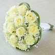 Captured in a soft, high-angle view, this classic bridal bouquet rests upon a light, textured fabric-a setting reminiscent of Stanmore's graceful event spaces. The centerpiece is a closely packed cluster of about twelve buttery yellow roses, each bloom pristine, their petals softly unfurling in gentle waves. Interspersed throughout are abundant sprays of delicate baby's breath, the tiny white blossoms forming a dreamy, cloud-like texture that enhances the bouquet's ethereal feel. Curved, deep green leaves frame the blooms, adding striking contrast and a contemporary touch. At the bouquet's base, the stems are gathered and wrapped in flawless white satin, forming a comfortable, polished handle ideal for holding during special celebrations in Stanmore. The overall impression is one of timeless elegance and heartfelt sentiment, harmonizing classic beauty with the distinctive calm of Stanmore's gardens and leafy streets. Perfect for weddings, vow renewals, or elegant gatherings, this bouquet encapsulates a sense of joy, purity, and skilled floral design, bringing a piece of Stanmore's tranquillity to any memorable occasion.