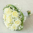 Seven prominent creamy-white roses take center stage in this carefully crafted bouquet, their petals unfolding in soft whorls that suggest both romance and restraint. Interspersed throughout are plentiful clusters of fresh, pure white gypsophila whose tiny blossoms create a cloudlike softness and visual lightness that lets the roses breathe. Artful loops of green bear grass thread through the design, forming graceful arcs that frame the blooms and add a contemporary kinetic line to the otherwise classic palette. The stems are bound into a comfortable handle and swathed in a silvery-white satin ribbon, its sheen interrupted by neat rows of small, iridescent pearl beads that glimmer subtly under soft studio lighting. Resting diagonally on a warm, light beige linen-like fabric, the bouquet's tones are enhanced by the textured backdrop-invoking the tactile hush of a bridal preparation table or a cosy family home on Marsh Lane. The scent is suggested rather than overpowering: a faint, fresh rose perfume mingling with the faint green scent of cut grass, an olfactory hint of spring mornings in Stanmore Common. This image conveys refined craftsmanship and gentle emotion, ideal for wedding galleries, ceremony planning, or quiet anniversary gestures; it also represents the sort of classic arrangement Flower Delivery Stanmore composes for couples exchanging vows near Stanmore Hill or for loved ones receiving comfort across the local neighbourhood.
