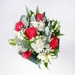 A hand-tied bouquet filled with velvety red roses, ruffled deep red carnations, and soft white daisies is shown from above, resting in gentle daylight like a moment of celebration captured in flowers. The blooms cluster together in a rounded shape, the crimson tones at the heart of the arrangement glowing warmly against the pure, snow-white petals of daisy-like chrysanthemums and tiny gypsophila. Sprays of baby's breath float between the larger flowers, their cloudlike clusters catching the light and giving the design an airy, joyful feel. Around the edge, eucalyptus stems arc gracefully, their rounded, silvery-green leaves mingling with darker tropical foliage to add depth and a modern edge. The textures are richly layered: smooth rose petals, feather-light carnation folds, crisp chrysanthemum centres, and delicate, almost misty gypsophila. The overall impression is balanced yet relaxed, as though an experienced florist in Stanmore has crafted it with both skill and instinct. It feels like a bouquet ready to brighten a birthday breakfast table on a quiet street off Stanmore Hill, to welcome someone home near Canons Park, or to bring warmth to a favourite reading corner. One can imagine the fresh, green scent of eucalyptus mingling with the gentle fragrance of the roses as the bouquet is delivered from a local studio, its colours echoing the cheerful mood of a sunny morning walk through Stanmore Country Park. This arrangement speaks of affection, congratulations, and simple, heartwarming moments shared at home.