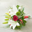 Set diagonally across a neutral, light beige backdrop with a faint woven texture, this bouquet looks as if it has just been placed on a dining table in Stanmore, moments before it is gifted for a wedding, engagement, or milestone anniversary. The eye is naturally drawn first to the generous white oriental lilies, their open, trumpet-shaped flowers spreading in graceful arcs. Each bloom reveals silky petals with slightly frilled edges and subtle reddish speckles that add character and depth. Between these open blooms are elongated green buds, still firmly closed, promising fresh lilies to come and extending the bouquet's life well beyond the first day. At the centre, a single deep red rose creates a striking focal point; its velvety petals curl inward in a perfect spiral, radiating a sense of timeless romance that suits the intimate celebrations often held around Stanmore Hill and Bentley Priory. Flanking the main flowers, two spherical 'Green Trick' dianthus appear as vivid, fuzzy tufts of bright green, their unusual, cushion-like texture offering a modern contrast to the classic, smooth petals. Airy sprays of white baby's breath, or gypsophila, thread their way between the larger forms, their tiny blossoms catching the light and lending a dreamy, cloud-like softness. Clusters of glossy red hypericum berries stand out like tiny beads of colour, mirroring the tone of the rose and adding a joyful, almost festive note. The arrangement is surrounded by an array of lush greenery, from broad dark leaves to fine, grass-like blades, which fan outward and give the piece a sense of organic movement. At the base, the stems are carefully bound with a wide, shimmering red satin ribbon that sits towards the bottom right corner, its sheen adding a final touch of refinement. Soft, natural light graze the flowers, casting gentle shadows and revealing the thoughtful craftsmanship of a skilled local florist, making this bouquet perfect for romantic deliveries across Stanmore and the surrounding HA7 area.