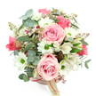 Set against a pristine white background, this blush pink hatbox arrangement appears serene and inviting, as though freshly finished on a florist's bench in Stanmore and ready to head out for delivery. The camera looks down from a slightly overhead angle, revealing the circular lid of the box and the lush, domed cluster of flowers that rise above it. The hatbox is a gentle pastel pink, encircled by a narrow ribbon in a slightly deeper rose shade, with a small cream tag suspended from the bow, hinting at a personalised, boutique creation. From this soft base, a garden-like mix of pink, white, and green blooms unfolds, capturing the calm, refined atmosphere of Stanmore's tree-lined avenues. Large light pink roses stand out as the main feature, their velvety petals arranged in tight spirals that gradually open into generous, layered cups, some fully open, others just beginning to reveal their centres. Clustered among them are white daisy-like chrysanthemums, each with a neat ring of petals surrounding a bright green centre, creating a cheerful contrast that feels fresh and modern. White alstroemeria stems weave gracefully through the design, their petals decorated with delicate purplish-red streaks and speckles that add fine detail and an exotic twist. The foliage provides depth and movement: rounded silvery-green eucalyptus leaves with a slightly matte texture, and darker, strappy green leaves that arc through the bouquet, shaping the overall dome. Here and there, small reddish-brown buds or berry-like elements punctuate the greenery, adding subtle warmth. The result is a beautifully balanced hatbox display, perfectly suited for a Stanmore delivery-perhaps to congratulate new homeowners near Canons Park, mark a birthday off Honeypot Lane, or send a gentle message of appreciation with flowers that arrive ready to enjoy straight from the box.