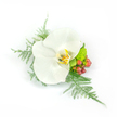 A quietly radiant white Phalaenopsis corsage photographed against a pristine white background so every tactile detail reads clearly. The central orchid is satiny and moon-white, its broad, waxy petals unfolding in a composed, symmetrical face; a gentle flush of buttery yellow and faint gold tones nestles in the throat, giving the blossom a warm, intimate centre. Fine sprays of asparagus fern fan out like soft tulle, their feathery, pale-green filaments drifting to the left and curling down toward the right, lending an airy, weightless motion. Nearby, compact clusters of glossy reddish-pink hypericum berries punctuate the composition with a tender, garden-fresh pop while a little lime-green chrysanthemum or textured filler sits close to the base, offering a crisp, verdant contrast. The arrangement is compact but cleverly asymmetrical-balanced so it can be pinned to a lapel or worn on the wrist without feeling rigid-an accessory that reads both refined and approachable. Light in the photo is soft and even, picking up the orchid's satin sheen and the fern's delicate shadow, creating a fresh, almost dewy impression as if assembled in the cool of an early morning. The overall mood is serene and celebratory, suitable for a wedding, prom, or any formal moment where understated luxury matters. A local Stanmore florist would describe this as a piece that feels at home near Canons Park or the village's High Street-an emblem of simple elegance crafted to be felt as much as seen, with the faint green scent of foliage and the orchid's smoothness inviting a tender, remembered touch.