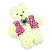 A soft and endearing teddy bear made from fresh flowers is centred in this image, standing out clearly against a pristine white background. The bear's figure is sculpted from numerous creamy white chrysanthemums, their layered petals forming a plush, cushion-like texture across the rounded head, full body, and compact limbs. Each bloom is placed precisely, so the silhouette appears smooth and cuddly, like a treasured stuffed bear. The facial features are minimal yet expressive: two tiny, dark circular elements serve as eyes, giving the bear a gentle, almost protective gaze, while a small dark nose and the hint of a curved mouth provide a sweet, comforting expression. Across the chest, a striking waistcoat effect is created using clusters of deeper pink, lilac, and mauve flowers, likely hydrangeas and coloured chrysanthemums, arranged symmetrically into two broad panels. These richer tones bring warmth and contrast to the otherwise pale design, adding a sense of personality. At the neckline, a dainty bow tied from sheer purple netting adds a final, whimsical flourish, its translucent texture catching subtle highlights from the even lighting. No foliage or additional decoration distracts from the teddy shape, allowing the viewer to appreciate the craftsmanship and purity of the idea. This kind of floral teddy bear is often chosen in Stanmore, Edgware, and surrounding HA7 neighbourhoods when a family desires a gentle, childlike tribute for a funeral or memorial, particularly for services at local chapels or cemeteries. It stands as a floral symbol of innocence, love, and the desire to wrap someone dear in one last, comforting embrace.