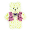 A tender floral teddy bear memorial stands out clearly against a plain white backdrop, allowing every bloom and detail to be easily seen. The bear is completely covered in creamy white chrysanthemums, their small, rounded petals packed closely together to create the impression of soft, plush fur. The shape is full and well-defined, with a broad tummy, rounded head, gentle ears, and short limbs that make the teddy appear both sturdy and comforting. Darker floral centres are carefully placed for the eyes and nose, adding depth and focus to the face, while subtle petal carving suggests a quiet, kind smile that feels warmly reassuring. Across the bear's chest is a beautifully arranged vest made from clusters of rich purple and soft mauve flowers. These petals are layered to form a neat V-shaped front with two clear lapels, like a little waistcoat someone might wear on a special day. Tucked under the chin rests a pale lavender mesh bow, light and translucent, softening the overall look with its airy folds and gentle shimmer. The arrangement exudes calm and thoughtfulness, the kind of tribute a family in Stanmore might choose when they want something both personal and symbolic for a funeral or memorial gathering. You can imagine the cool touch of the chrysanthemums and their mild, fresh fragrance filling a quiet room in one of the local chapels or homes. This floral teddy bear is a heartfelt sympathy design, a way to express love, innocence, and cherished memories when remembering a child or someone whose presence brought simple, genuine joy.
